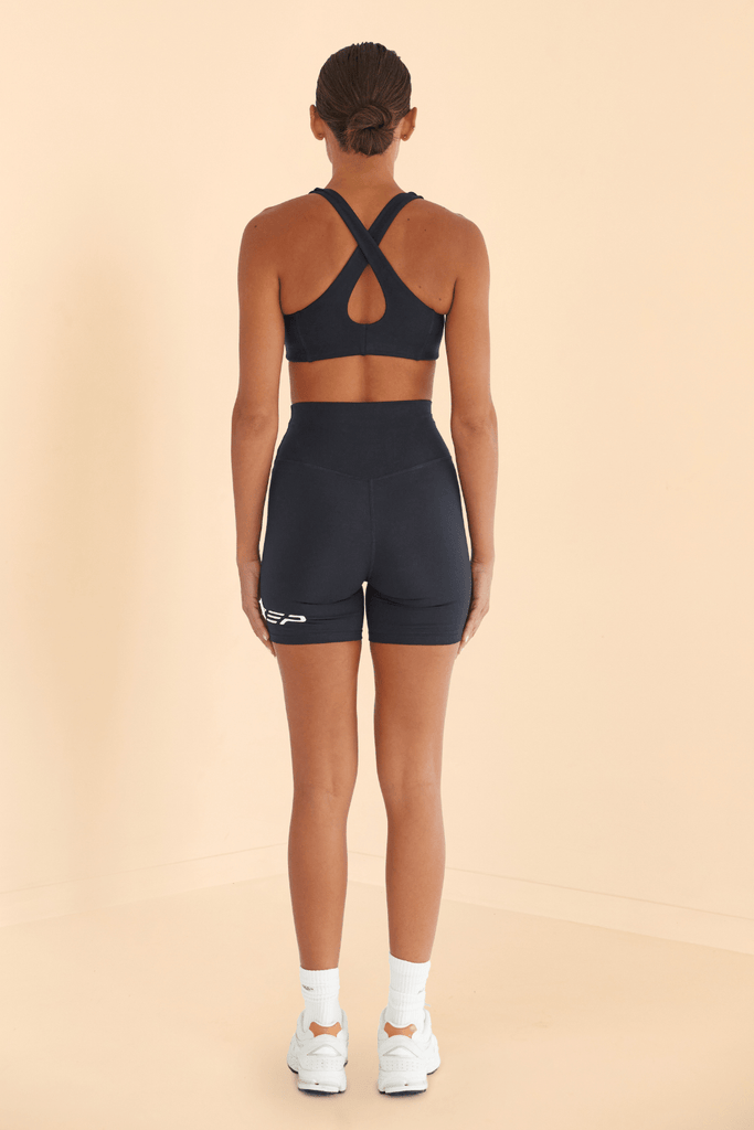 SZEP Black sports bra with racer back design, removable bra padding and white szep logo on left side align with stitching